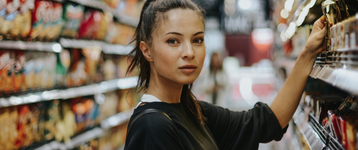 Quelles sont les tendances de la distribution ? Une femme en train de choisir des produits dans les rayons d'un supermarché