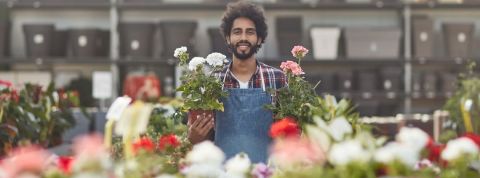 La revanche des marques locales Fleuriste avec des pots dans les mains souriant