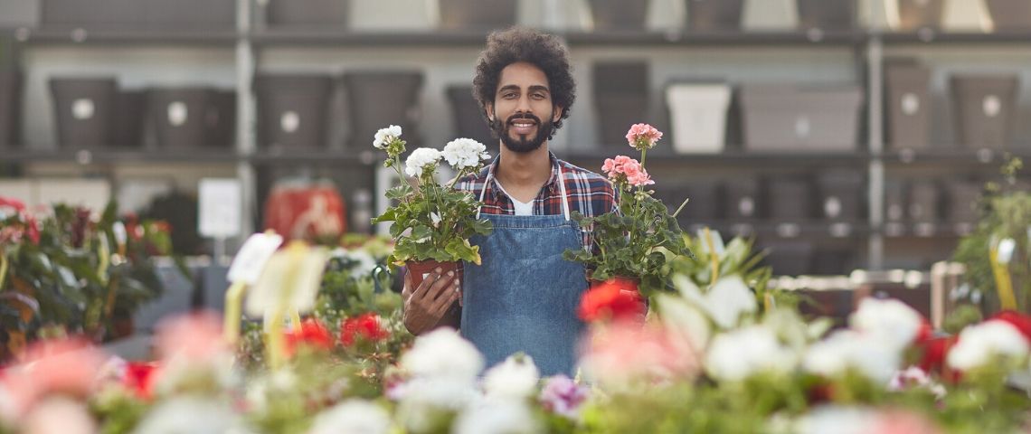 La revanche des marques locales Fleuriste avec des pots dans les mains souriant