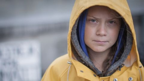une jeune fille en imperméable jaune qui fixe la caméra