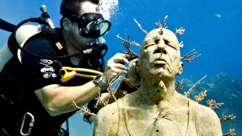 un plongeur sculpte sous l'eau
