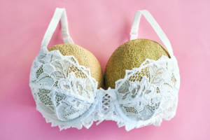 des melons dans un soutien-gorge blanc sur fond rose