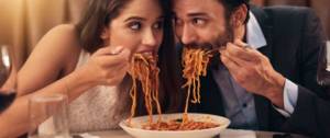 Un couple qui mange des pâtes côte à côte