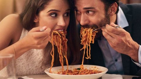Un couple qui mange des pâtes côte à côte