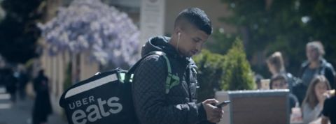 Bilil, micro travailleur pour Uber Eats un jeune homme dans la rue tient son téléphone entre ses mains