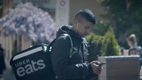 Bilil, micro travailleur pour Uber Eats un jeune homme dans la rue tient son téléphone entre ses mains