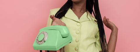 C'est quoi Photo Roulette? Une femme tenant un téléphone sur fond rose