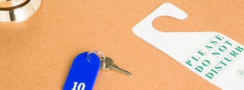 10 mesures pour éviter les cyberattaques Un porte clé et une affiche ne pas déranger posé sur une table