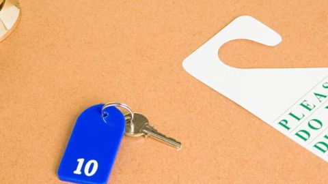 Un porte clé et une affiche ne pas déranger posé sur une table