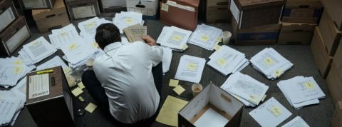 Comment le film Dark Waters révèle le scandale du C8 Mark Ruffalo dans le film Dark Waters, accroupi et de dos en train de travailler sur le dossier DuPont