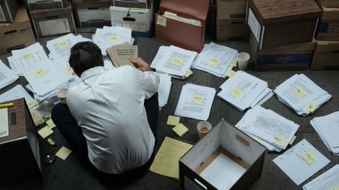 Mark Ruffalo dans le film Dark Waters, accroupi et de dos en train de travailler sur le dossier DuPont