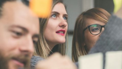 des personnes travaillent en équipe et regardent un tableau