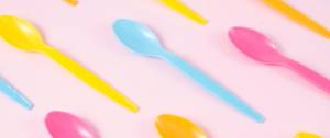 des cuillères en plastique fluo sur fond rose