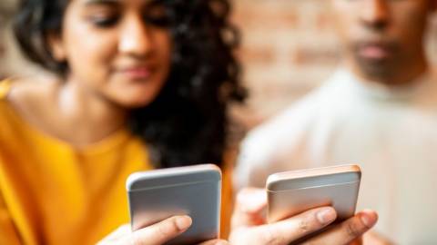 Une femme et un homme qui regarde leur smartphone