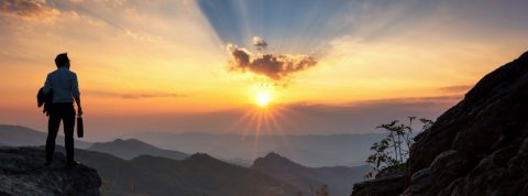 Comment les dirigeants peuvent-ils gérer la crise du coronavirus ? Un homme au sommet d'une montagne en train d'assister au lever du soleil