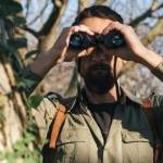 Un homme dans la jungle avec des jumelles