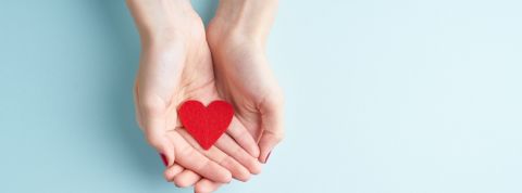 Coronavirus : comment les entreprises peuvent-elles s'engager ? deux mains de femme tenant un coeur en papier rouge