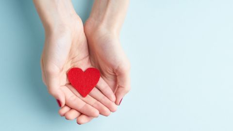 Coronavirus : comment les entreprises peuvent-elles s'engager ?  deux mains de femme tenant un coeur en papier rouge