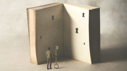 un livre ouvert avec des serrure et une personne qui a la clé