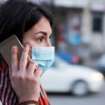 Une femme portant un masque de protection au téléphone