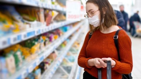 Une masque qui fait ses courses dans un supermarché avec un masque