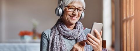 Les rendez-vous culturels sur les réseaux sociaux Une femme avec les cheveux blanc qui regarde son smartphone