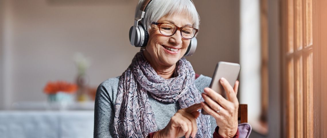 Les rendez-vous culturels sur les réseaux sociaux Une femme avec les cheveux blanc qui regarde son smartphone