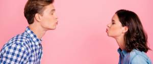 Un homme et une femme qui se font un bisou à distance sur un fond rose