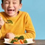 Un enfant qui mange des brocolis