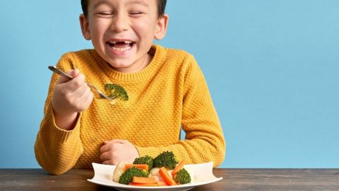 Un enfant qui mange des brocolis