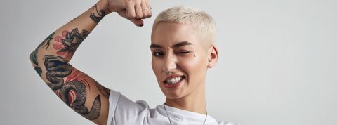 Les marques doivent oser l'audace Une jeune femme aux cheveux courts plie son biceps