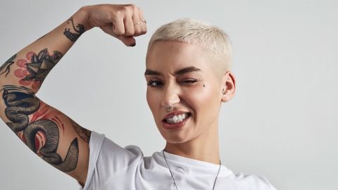 Les marques doivent oser l'audace Une jeune femme aux cheveux courts plie son biceps