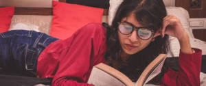 Une femme indienne lisant un livre sur son lit