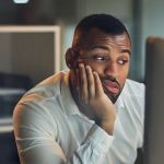 Un homme qui regarde son écran d'ordinateur dépité