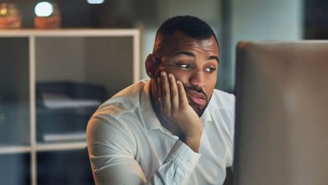 Un homme qui regarde son écran d'ordinateur dépité