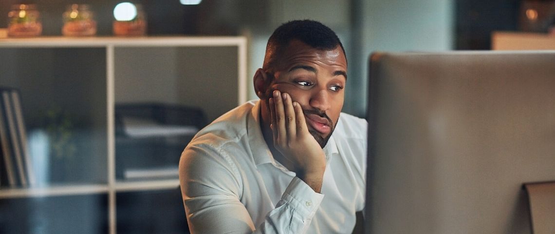Une étude sur les messages restés sans réponse Un homme qui regarde son écran d'ordinateur dépité