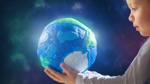 un jeune enfant tenant un globe lumineux entre ses mains
