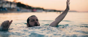 un homme barbu en train de se noyer