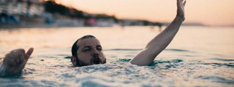 Le journalisme web est sous l'eau un homme barbu en train de se noyer