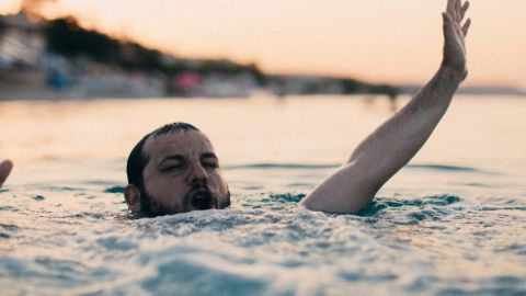 un homme barbu en train de se noyer