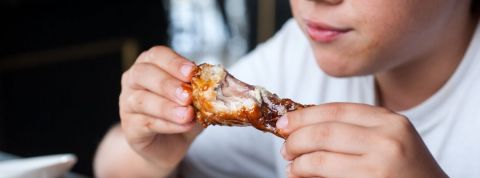 On continue à manger de la viande Un enfant qui mange une cuisse de poulet