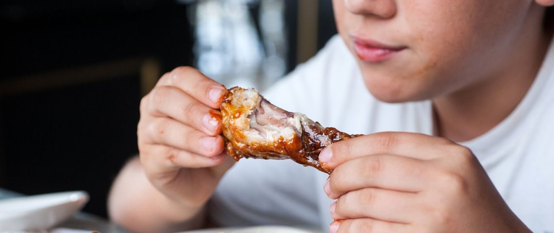 On continue à manger de la viande Un enfant qui mange une cuisse de poulet