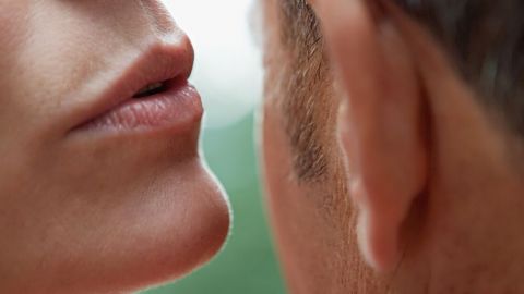 Une femme chuchotte un secret à l'oreille d'un homme