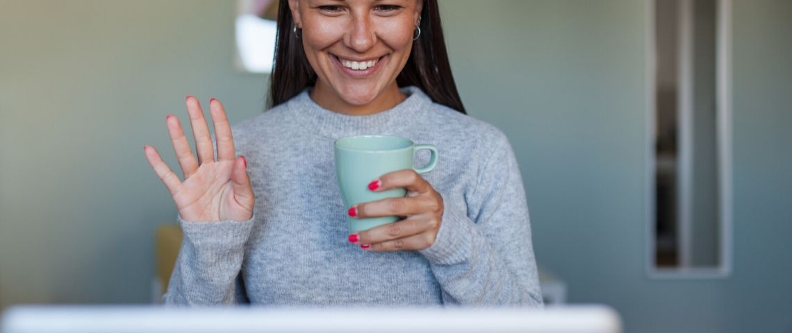 Le télétravail nous apprend le télémanagement Une jeune femme assise devant son ordinateur et qui fait une videoconférence