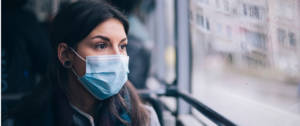 Une femme dans un bus portant un masque chirurgical