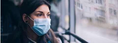 Comment ça se passe pour les gens qui sont obligés d'aller travailler pendant la pandémie ? Une femme dans un bus portant un masque chirurgical