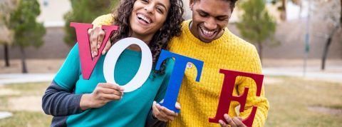 Les meilleurs moyens pour inciter les électeurs à voter Un homme et une femme qui tienne des lettres qui forment le mot VOTE