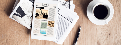 Les meilleures analyses de la crise du covid-19 Des journaux posés sur une table avec une tasse de café et des lunettes