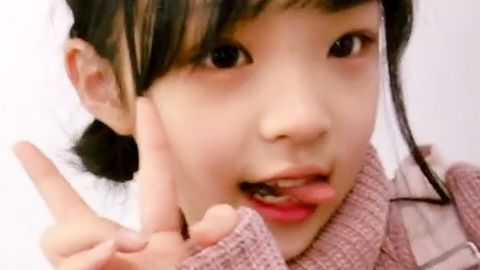 Une petite fille asiatique fait le signe V de victoire