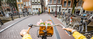jeune femme en pull jaune sur un vélo à Amsterdam